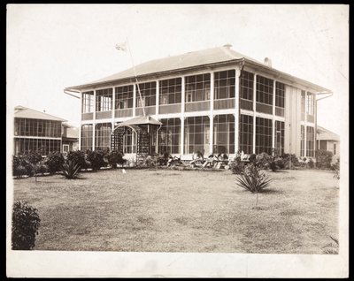 A Two-Story House Surrounded by Porches, with an American Flag Flying; in Panama During the Construction of the Canal by Byron Company